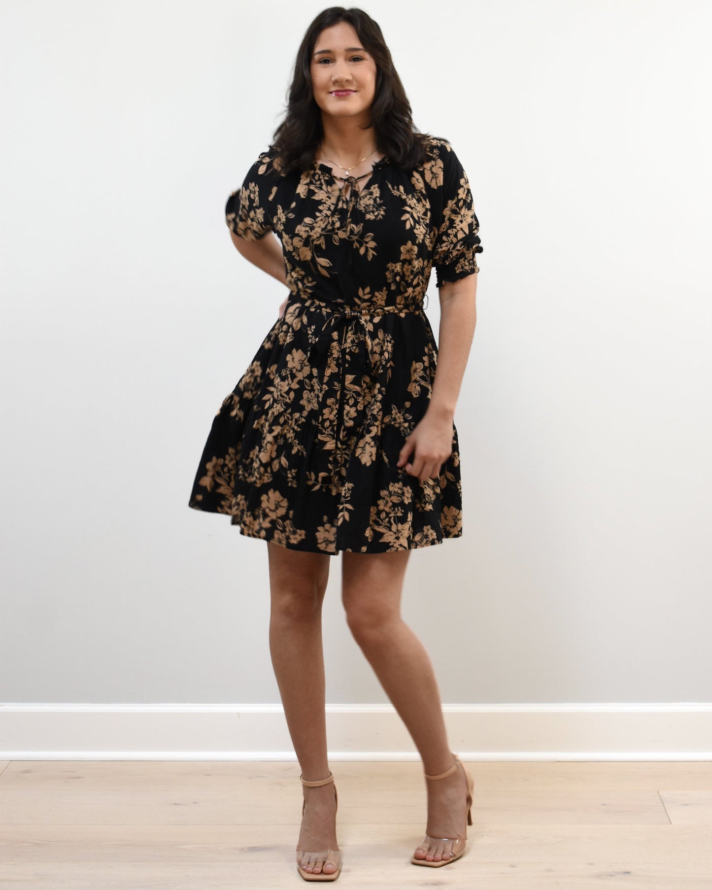 Kelly Mini Dress on soft linen background, featuring a ruffle neckline with tie and lightweight cotton–rayon fabric.