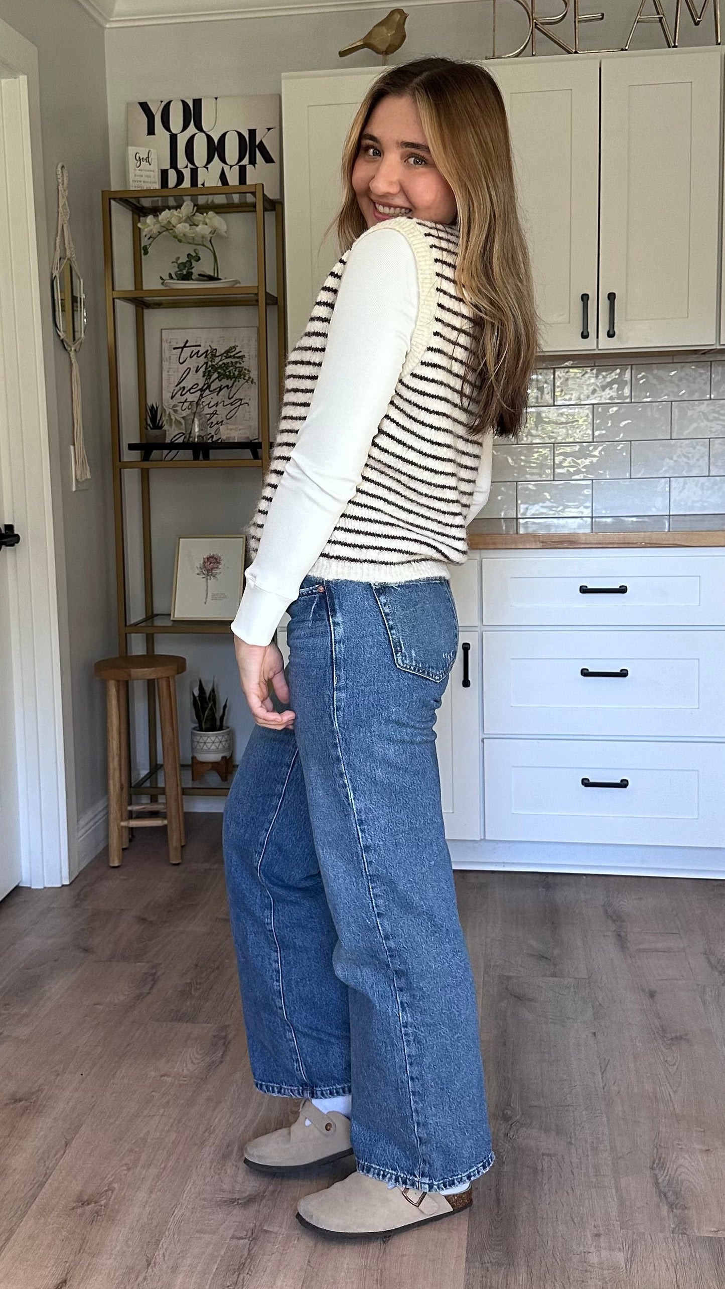 Textured button-front vest layered over a long-sleeve top