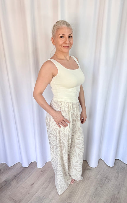 Side view of women's island leaf print straight leg pants with hand in pocket, showcasing the relaxed fit and lightweight rayon linen fabric.