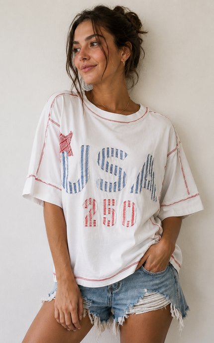 Woman wearing a white t-shirt with 'USA 250' print against a plain background