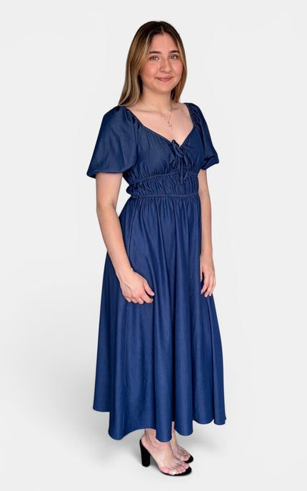 Side view of a French blue midi dress featuring a smocked bodice, sweetheart neckline, and flowy skirt.