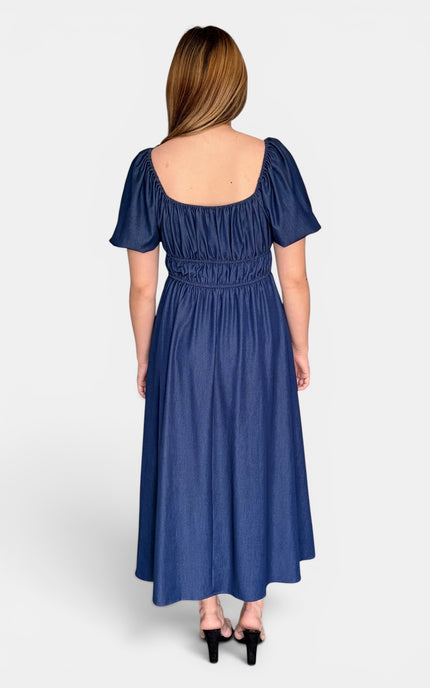 Back view of a French blue Tencel midi dress with a smocked back and bubble sleeves.