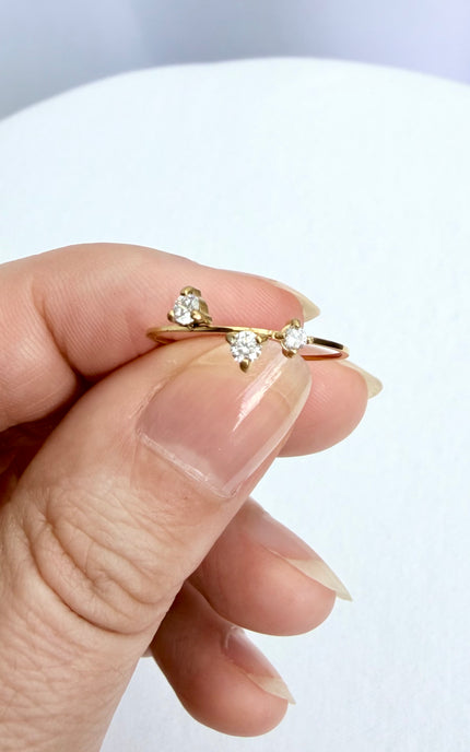 A dainty, waterproof stainless steel three-stone ring displayed in a hand to show its ultra-lightweight design and delicate scale.