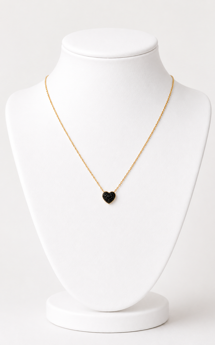 A delicate gold chain necklace with a small black heart-shaped pendant, displayed on a white jewelry bust against a clean white background.