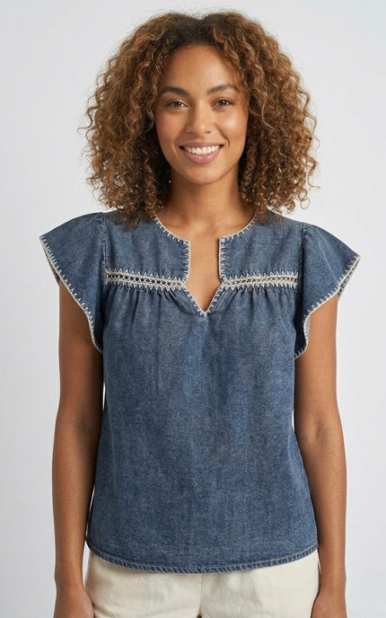 Women's blue Tencel denim blouse with white embroidered trim.