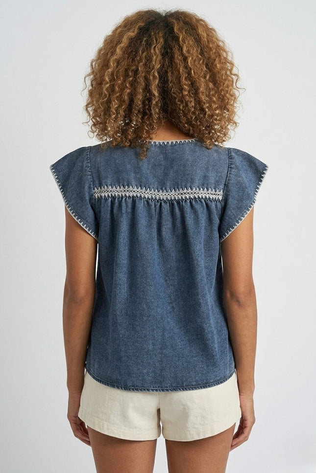 Back view of women's indigo embroidered denim top.