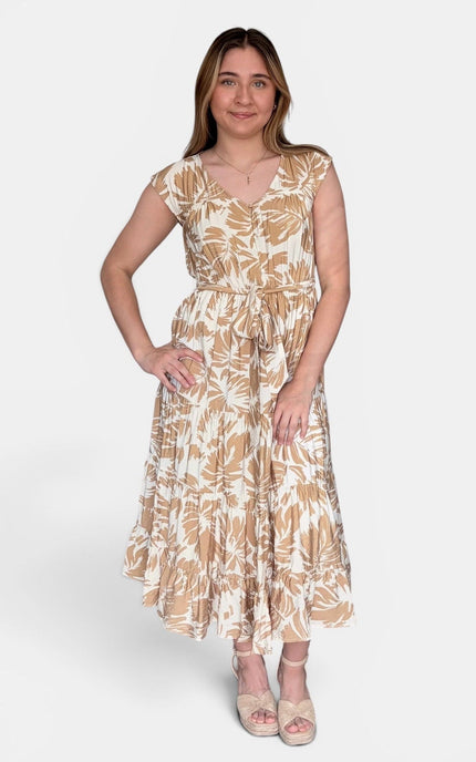 Sleeveless midi dress with a beige and white tropical leaf pattern, standing against a light gray studio background.