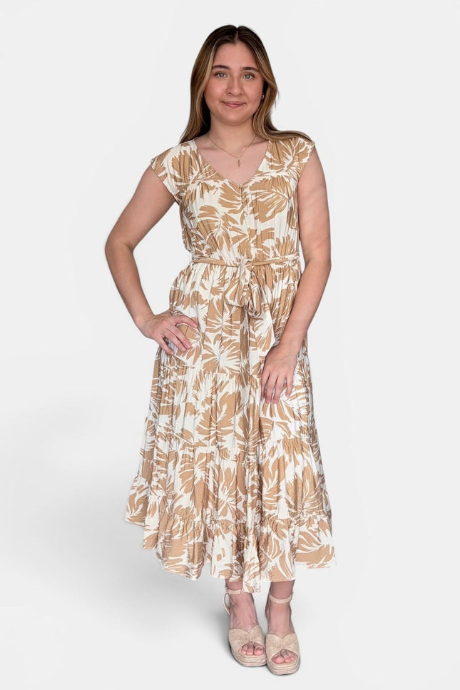 Sleeveless midi dress with a beige and white tropical leaf pattern, standing against a light gray studio background.
