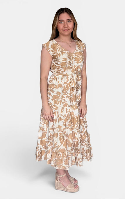 Sleeveless midi dress with a beige and white tropical leaf pattern, paired with beige wedge sandals, against a light gray studio background.