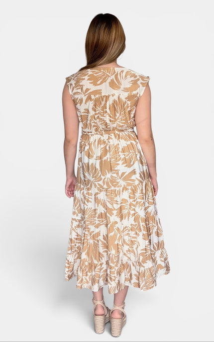 Back view of sleeveless midi dress with a beige and white tropical leaf pattern, paired with beige platform sandals, against a light gray studio background.