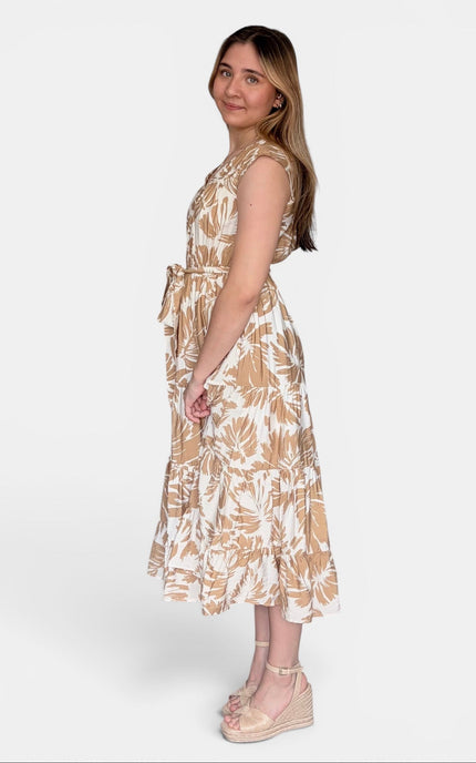 Side view of sleeveless midi dress with a beige and white tropical leaf pattern, standing against a light gray studio background.