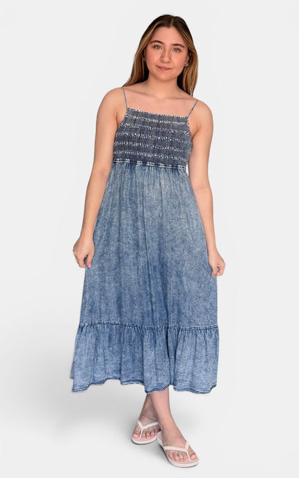 Sleeveless blue Tencel midi dress featuring a smocked bodice and flowy tiered silhouette.