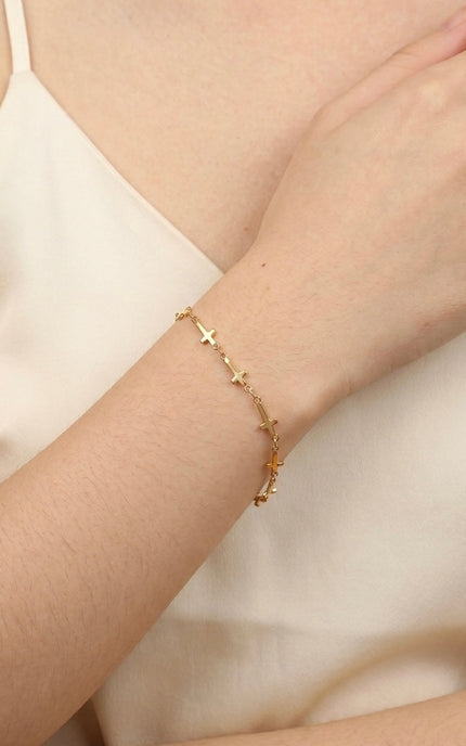 Cross‑station bracelet worn alone for a quiet, meaningful everyday look.