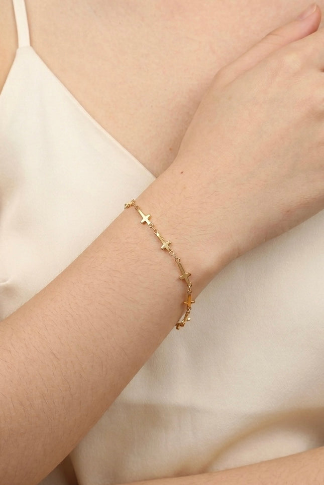 Cross‑station bracelet worn alone for a quiet, meaningful everyday look.