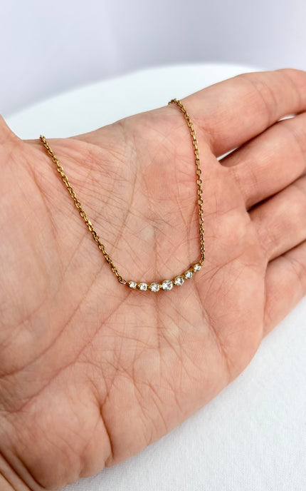 Zircon bar necklace resting in an open palm, showing delicate scale and subtle sparkle.