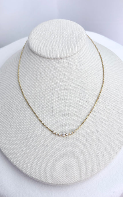 Zircon bar necklace displayed on a neutral jewelry form, showing the slim gold chain and subtle sparkle of the stone row.