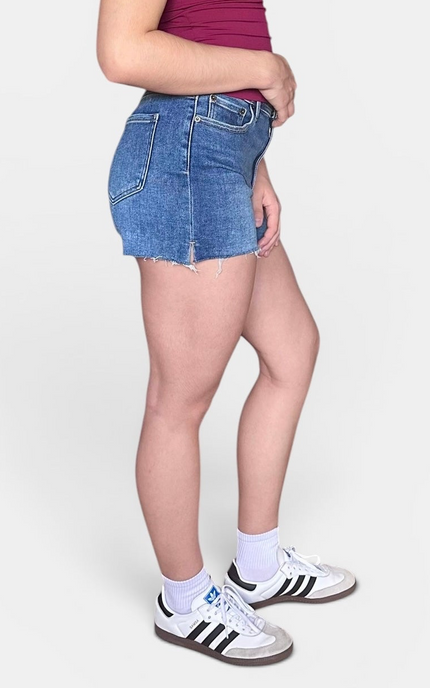 Side view of high-rise denim shorts with a raw hem and comfortable stretch denim.