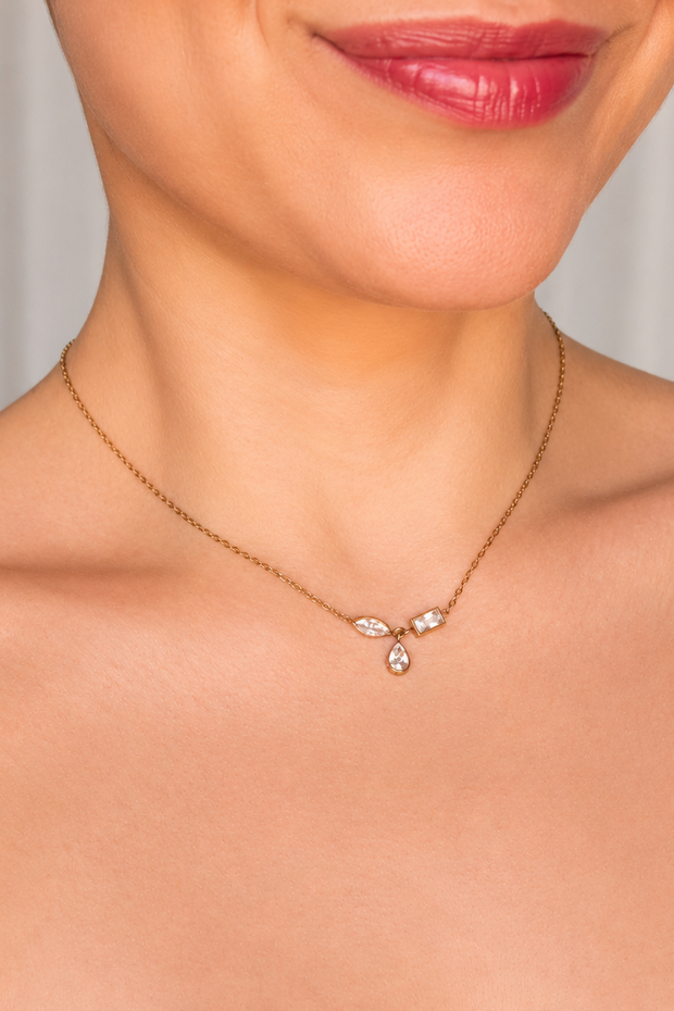 Gold necklace with small rhinestones on a person's neck