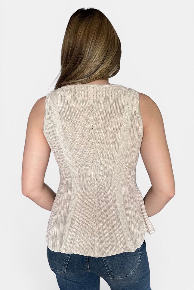 A woman viewed from the back wearing a sleeveless ribbed knit peplum top in a light beige or cream color, paired with blue jeans, against a plain light gray studio background.