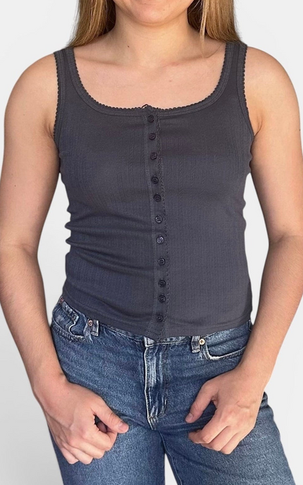 A woman wearing a dark charcoal gray ribbed tank top with a button-down front and scalloped scoop neckline, paired with blue jeans.