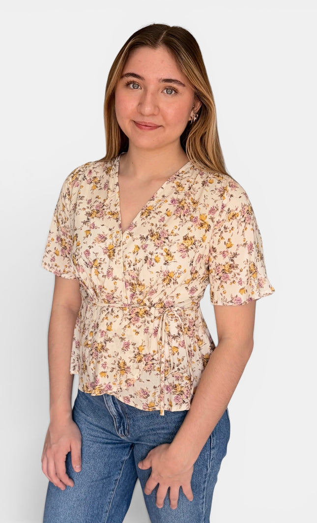 Women's floral wrap top with a soft drape, pleated bust, and adjustable waist tie.
