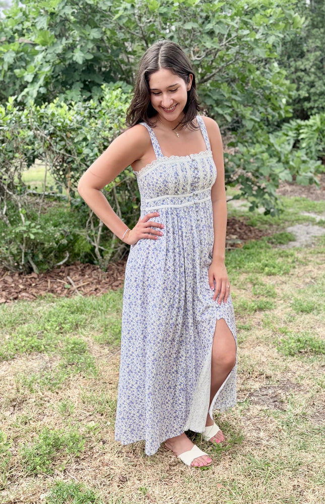 Side profile of the floral maxi dress highlighting the contrasted piping and flowing skirt.