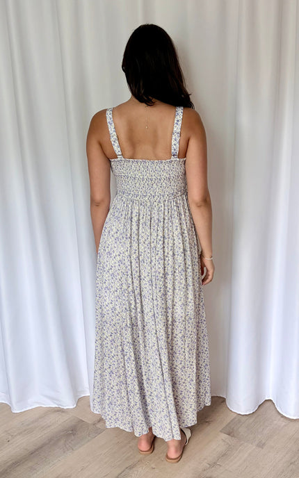 Back view on model highlighting smocked panel and adjustable straps.