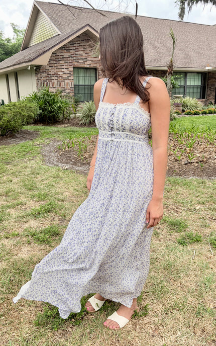 Side profile of the floral maxi dress highlighting the contrasted piping and flowing skirt.