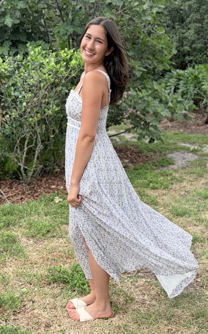 Side profile of the floral maxi dress highlighting the contrasted piping and flowing skirt.