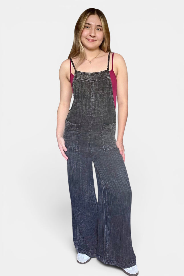 Black 100% cotton wide leg jumpsuit featuring adjustable shoulder straps and a relaxed fit.