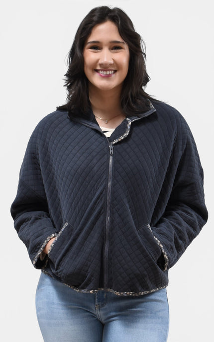 Front view of women's quilted zip-up jacket with floral contrast accents.