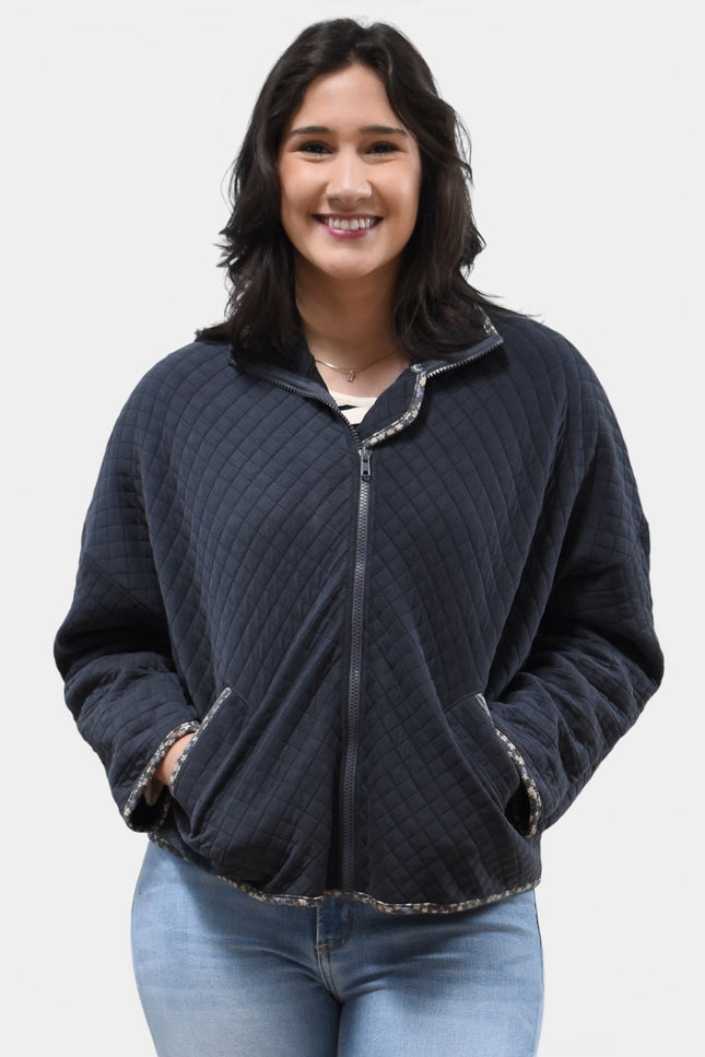 Front view of women's quilted zip-up jacket with floral contrast accents.