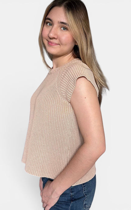 Beige ribbed knit sleeveless top with cap sleeves, paired with blue jeans, shown from a side profile against a light gray background.