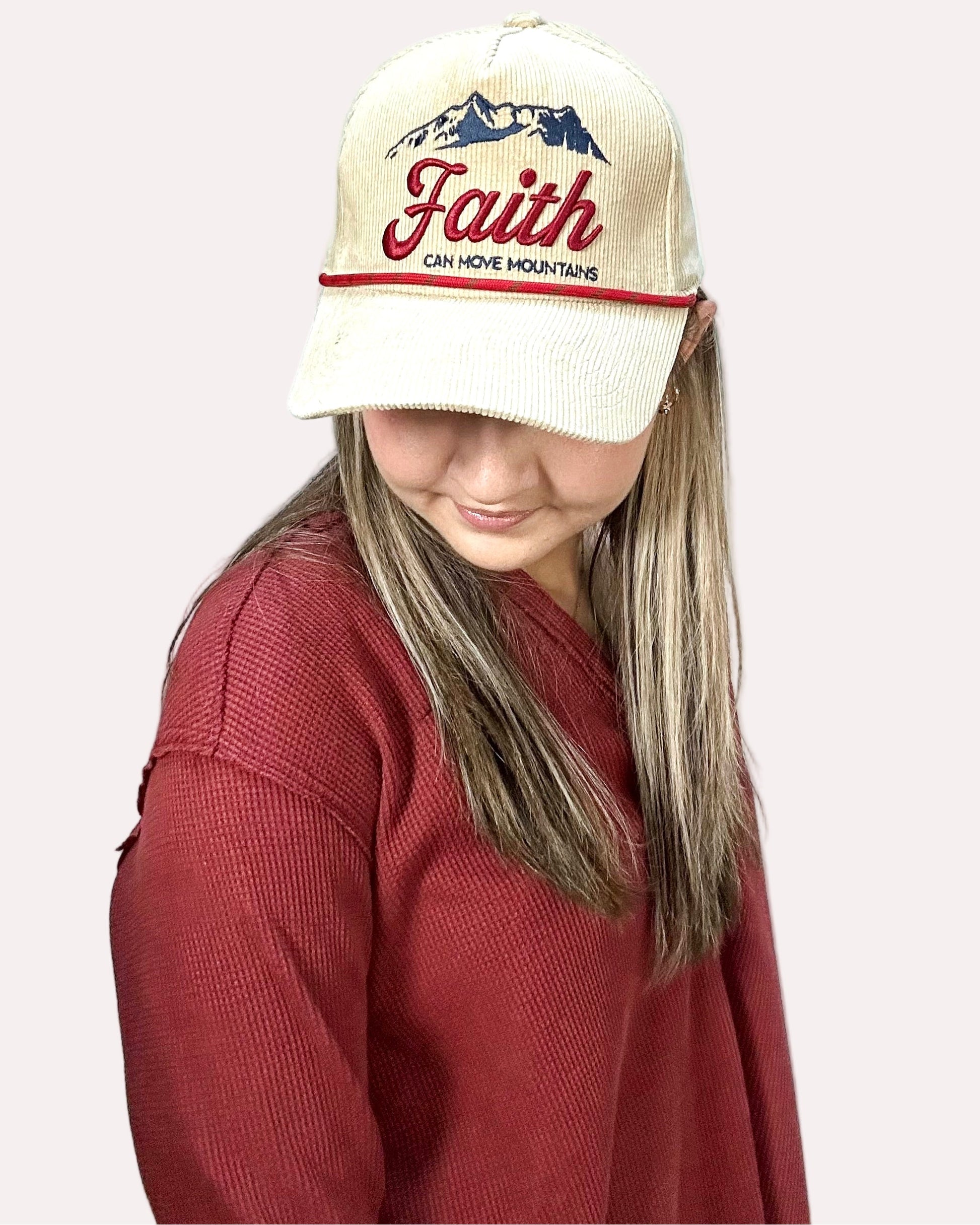 Person wearing a cap with 'Faith Can Move Mountains' text on a plain background