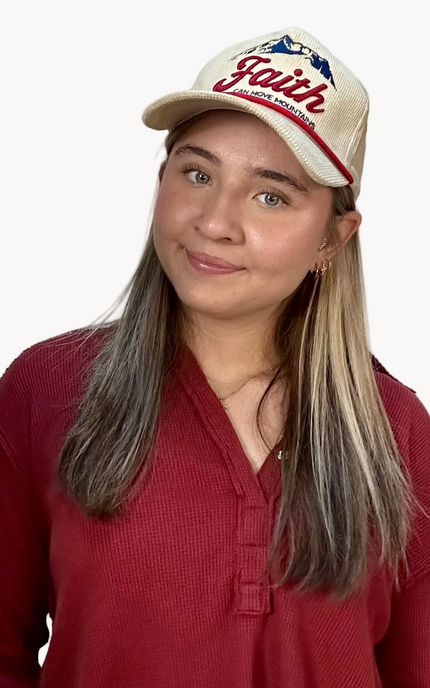 Woman wearing a red shirt and a cap with 'Faith' text on a white background