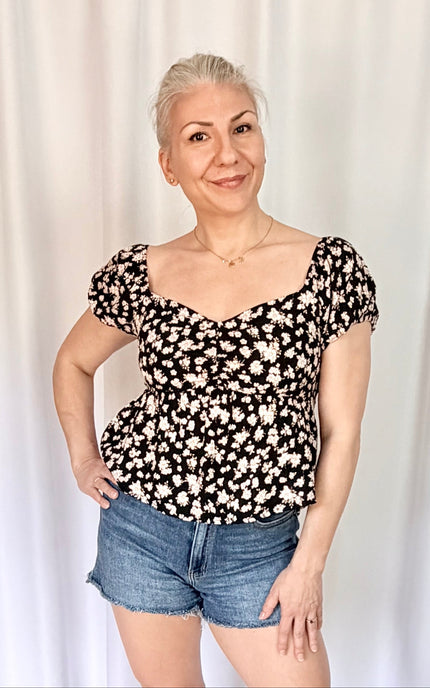 Front view of floral print blouse with puff sleeves and versatile on or off shoulder styling.