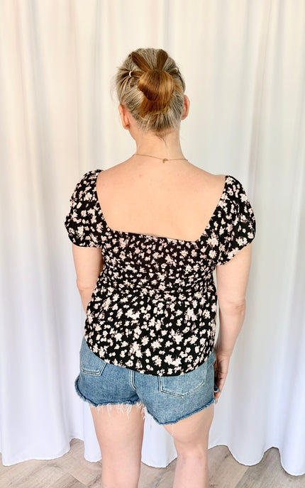 Back view of women's floral sweetheart top with elastic puff sleeves and lightweight rayon fabric.