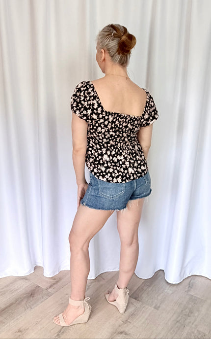 Back view of romantic floral puff sleeve top with smooth lightweight finish.