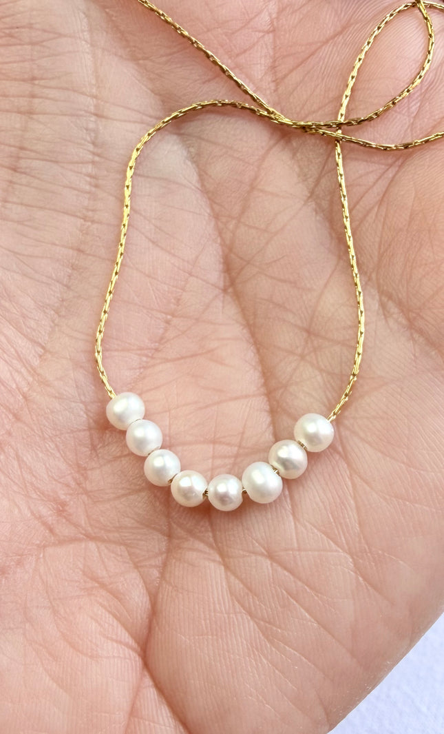 Gold chain necklace with natural freshwater pearl detail.