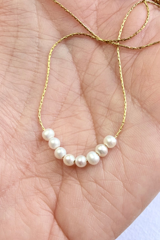 Gold chain necklace with natural freshwater pearl detail.