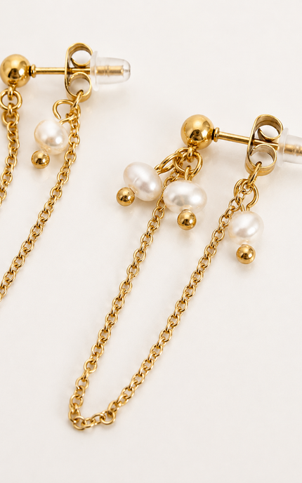 Gold chain drop earrings with dangling white faux pearls and gold ball accents, shown on a clean white background.