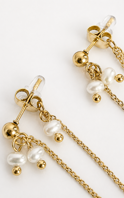 Gold dangle earrings with barbell studs, small pearl beads, and chain drops on a clean white background.