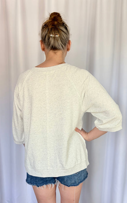 Back view of the lightweight French terry top, showcasing the clean round neckline finish, sporty raglan sleeve seams, and a relaxed, comfortable silhouette.