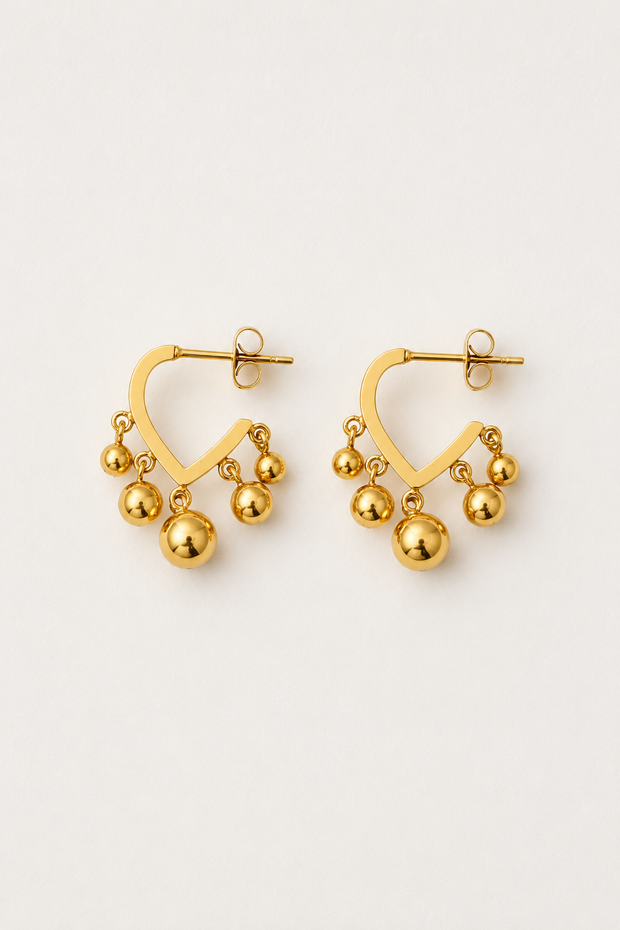 Open V-shaped 18k gold hoop earrings with polished dangling gold ball beads on a light neutral background.