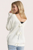 Off-white ribbed sweater with lace-trim V-neckline and oversized bow detail draping down the back, photographed on a Soft Linen background for Justyna Grace Boutique.