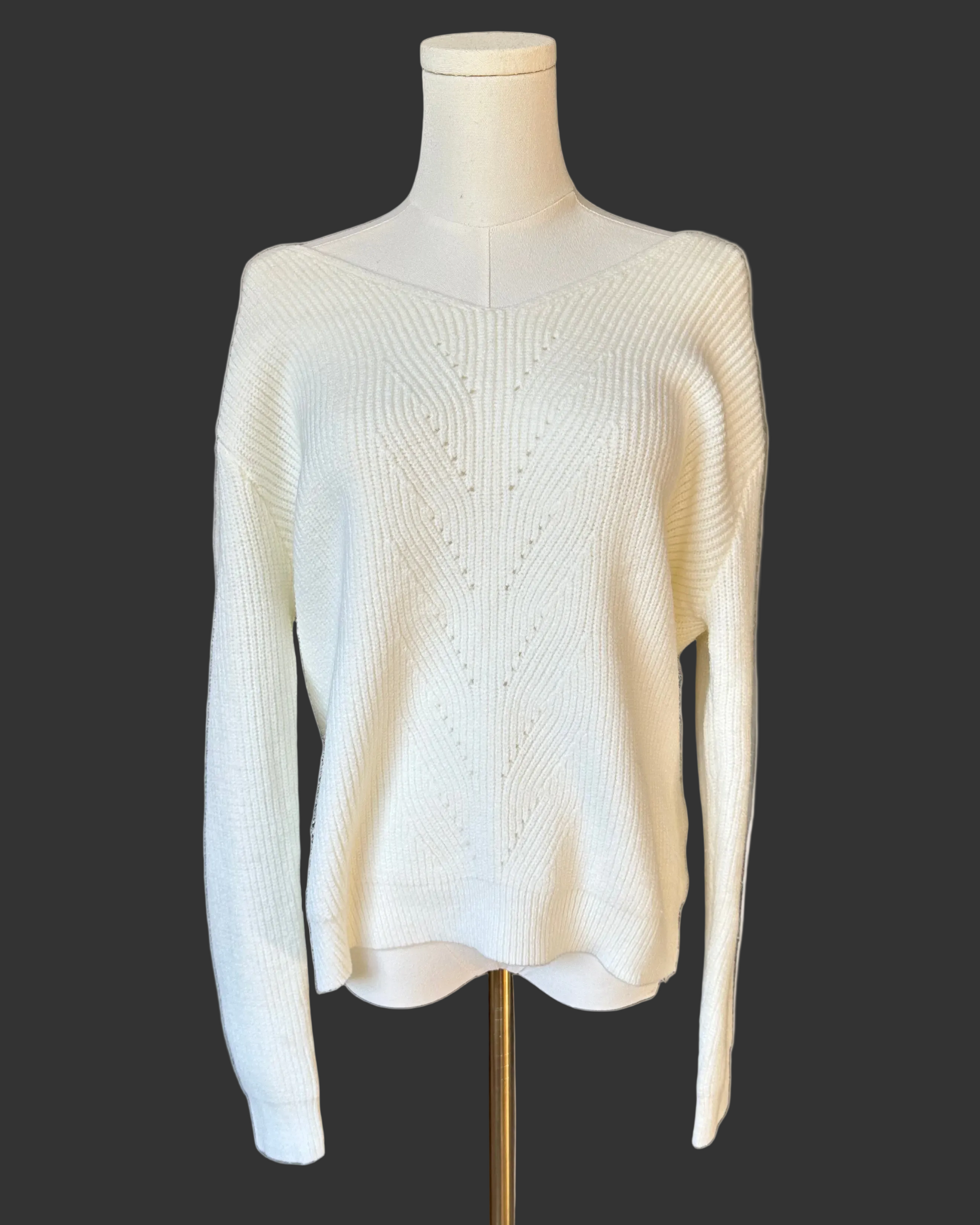 Off-white ribbed sweater with lace-trim V-neckline and oversized bow detail draping down the back, photographed on a Soft Linen background for Justyna Grace Boutique.