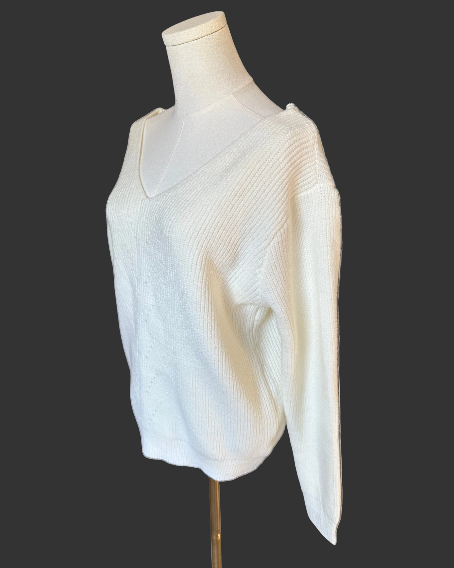 Off-white ribbed sweater with lace-trim V-neckline and oversized bow detail draping down the back, photographed on a Soft Linen background for Justyna Grace Boutique.