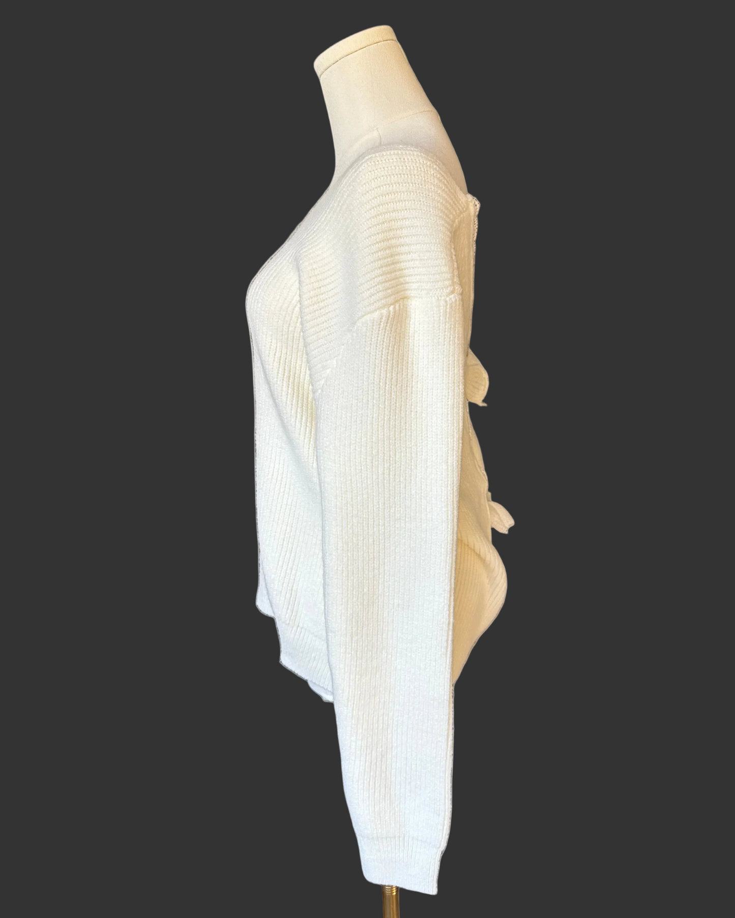 Off-white ribbed sweater with lace-trim V-neckline and oversized bow detail draping down the back, photographed on a Soft Linen background for Justyna Grace Boutique.