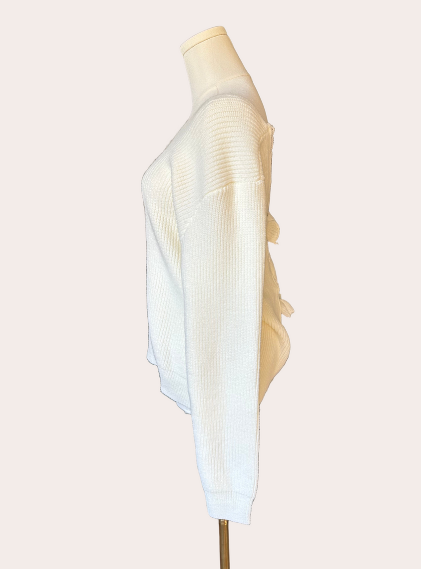 Off-white ribbed sweater with lace-trim V-neckline and oversized bow detail draping down the back, photographed on a Soft Linen background for Justyna Grace Boutique.