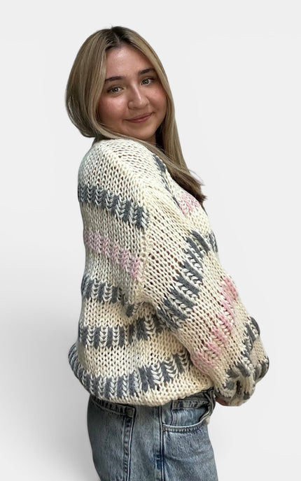 Cozy ivory striped sweater with a chunky knit texture and drop shoulders.